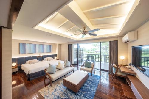 duża sypialnia z łóżkiem i balkonem w obiekcie Okuma Private Beach & Resort w mieście Kunigami