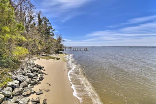 a beach with rocks and a pier in the water at Gloucester Retreat with Backyard Oasis and Pier! in Gloucester