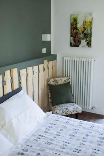 a bedroom with a bed and a chair at Storie di bosco in Villa Lagarina