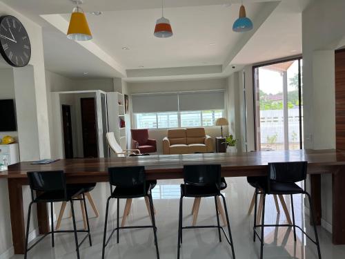 a dining room with a large wooden table and chairs at 92 Chiangrai poshtel in Ban Fang Min