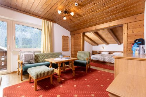 a hotel room with a bed and a table and chairs at Hotel Garni Villa Knauer in Mayrhofen