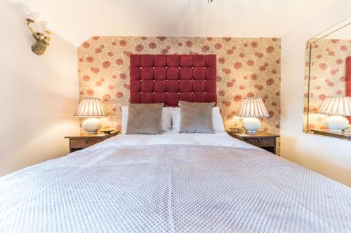 a bedroom with a large bed with two lamps at Sandbeds Farmhouse in Kendal