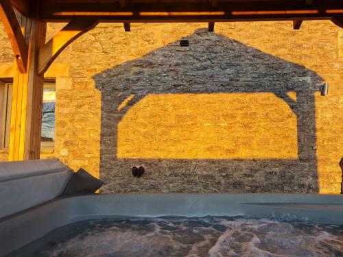 a stone wall with a hot tub in front of a building at Keld Barn, Low Ploughlands Holiday Lets in Kirkby Stephen