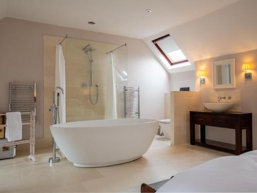 a large white bathroom with a tub and a sink at Stow House in Stow on the Wold