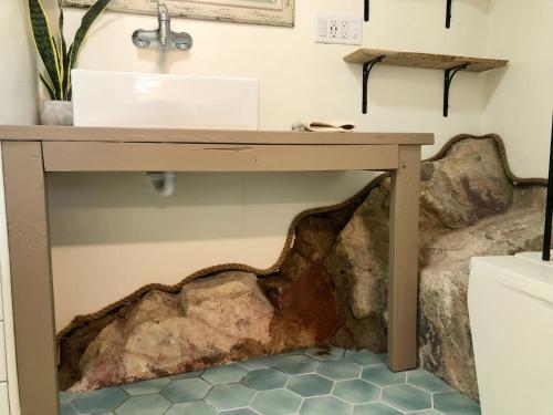 uma mesa de madeira com um lavatório na casa de banho em NEW! Prickly Pear Unique Studio with bathroom built into the rocks em Prescott
