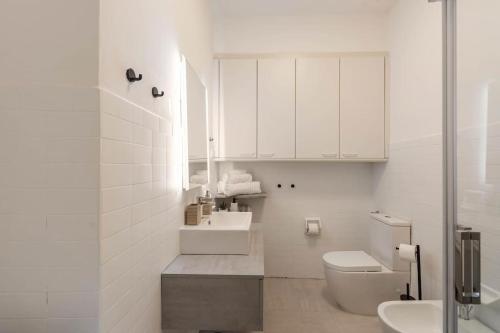 ein weißes Badezimmer mit Toilette und Waschbecken in der Unterkunft Lauben Apartment Bolzano in Bozen