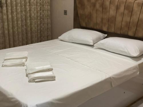 łóżko z białą pościelą i białymi poduszkami w obiekcie Sumgait Boulevard w mieście Sumgait