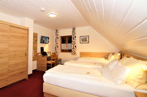 a bedroom with two beds and a desk at Gasthaus und Landhotel Wiedmann in Eresing