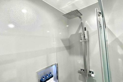 a shower in a bathroom with a glass door at Stunning Luxury Apartment Near Motherwell in Wishaw