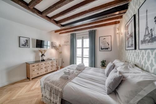 1 dormitorio con 1 cama grande y TV en AMAZING HISTORICAL PARISIEN LOFT NEXT TO LOUVRE AREA !, en París