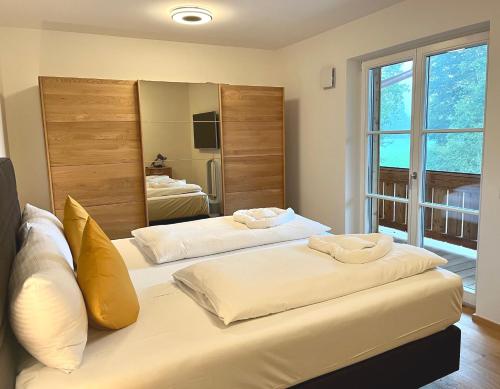 two beds in a room with a mirror at Palais Karl-Theodor in Rottach-Egern