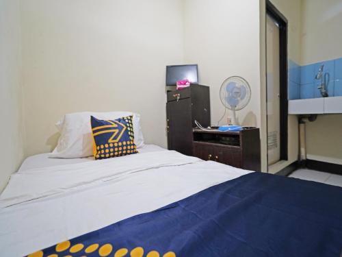 Tempat tidur dalam kamar di SPOT ON 91783 Urban Syariah Residence