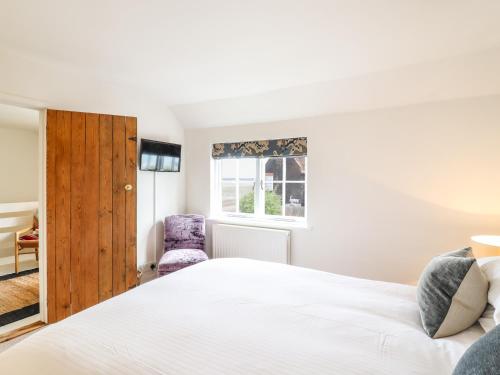 Schlafzimmer mit einem Bett und einem Fenster in der Unterkunft Wherry Cottage in Manningtree
