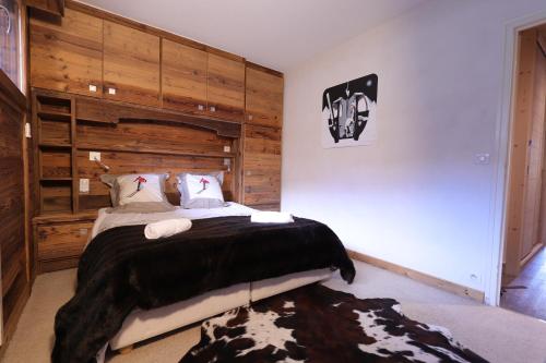um quarto com uma cama e uma parede de madeira em Tignes le Lac - Le Santon bel appartement 4 pers em Tignes