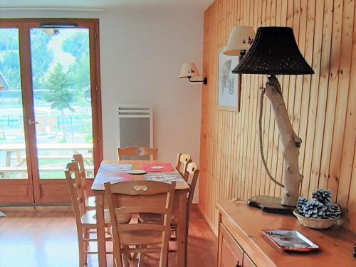 une salle à manger avec une table et une lampe sur un bureau dans l'établissement Charmant Chalet Duplex 6 Pers, Résidence 3* avec Piscine, Superdevoluy, à 300m des Pistes - FR-1-504-634, à Superdevoluy