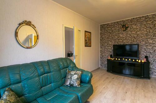 ein Wohnzimmer mit einem grünen Sofa und einem TV in der Unterkunft Randla 14 Tallinn in Tallinn