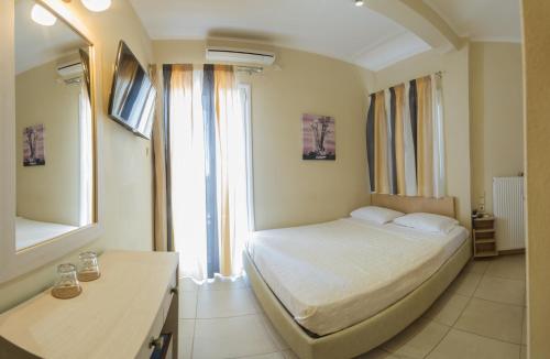 a bedroom with a bed and a large window at San Nectarios in Parga