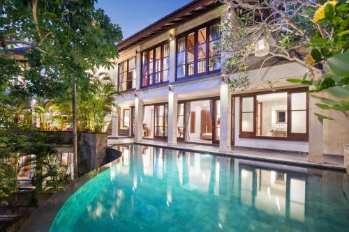 an exterior view of a house with a swimming pool at Gending Kedis Luxury Villas & Spa Estate in Jimbaran