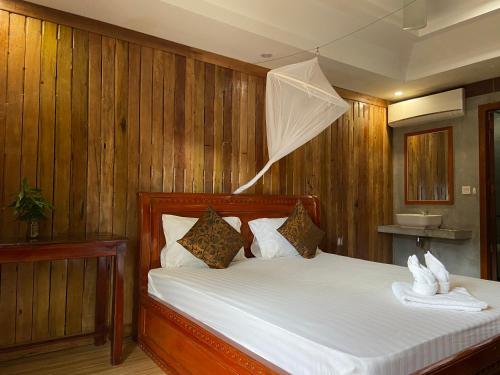 a bedroom with a bed with a net on it at Sothea Angkor Homestay in Phumi Ta Phul