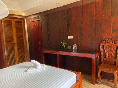 a bedroom with a bed and a chair and a desk at Sothea Angkor Homestay in Phumi Ta Phul