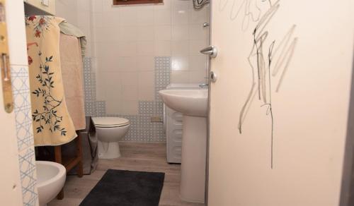 La salle de bains est pourvue de toilettes blanches et d'un lavabo. dans l'établissement Oleandro, à Marina di Campo
