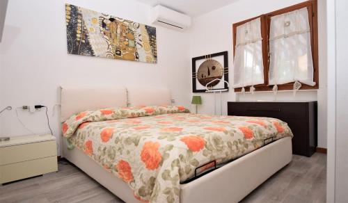 Un dormitorio con una cama con un edredón floral. en Oleandro, en Marina di Campo