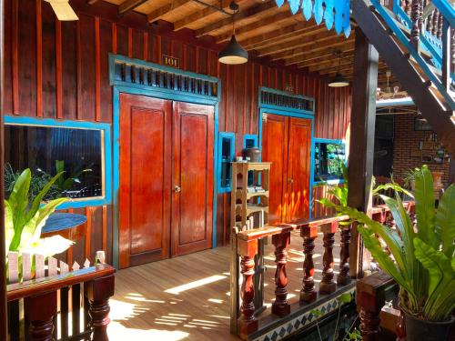a house with wooden walls and wooden doors at Sothea Angkor Homestay in Phumi Ta Phul