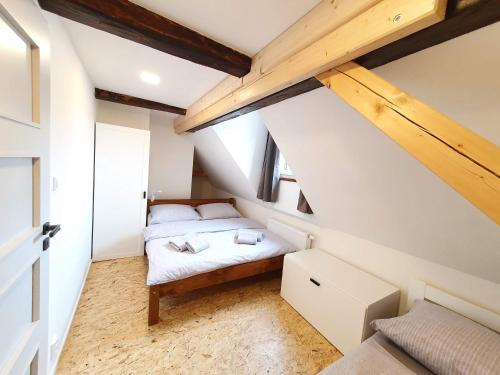a small bedroom with a bed in a attic at Apartmány U Muzea in Horní Blatná