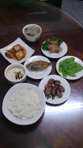 a table with white plates of food on it at De Ren Tea Gardens in Meishan