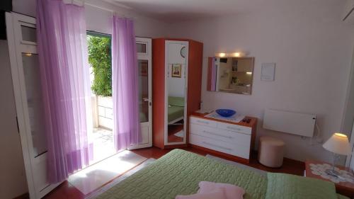 ボルにあるStudio apartment in Bol with sea view, terrace, air conditioning, WiFi 3634-1のベッドルーム1室(ベッド1台付)、紫色のカーテン付きの窓が備わります。