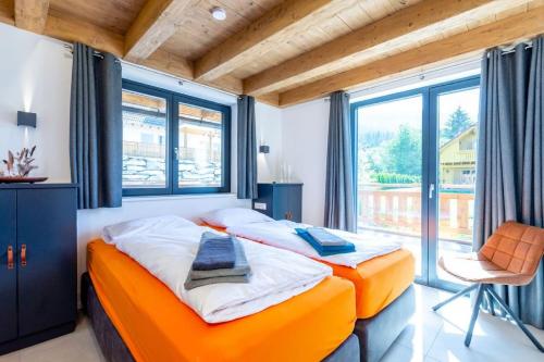 two beds in a room with a large window at Chalet Coquette Vigny^Hadley in Saint-Michel-de-Maurienne