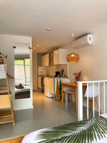a kitchen and living room with a table and a dining room at B&B Berglust Rotterdam met serre en gratis parkeren in Rotterdam