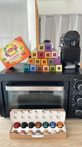 un micro-ondes avec une boîte de beignets dessus dans l'établissement Home Up Pontoise, à Pontoise