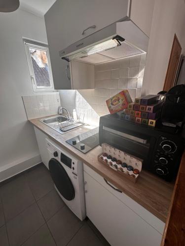 a small kitchen with a sink and a stove at Home Up Pontoise in Pontoise