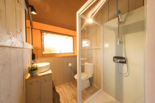 een badkamer met een douche, een toilet en een wastafel bij Camping Vendrell Platja in Comarruga
