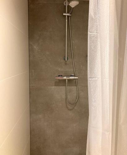 La salle de bains est pourvue d'une douche avec rideau de douche. dans l'établissement B&B Berglust, à Rotterdam