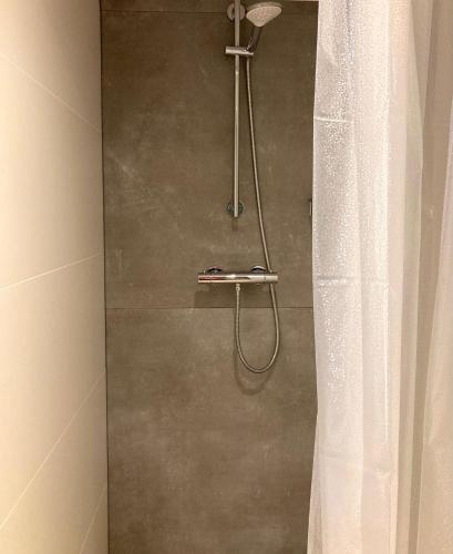 a shower with a shower curtain in a bathroom at B&B Berglust Rotterdam met serre en gratis parkeren in Rotterdam