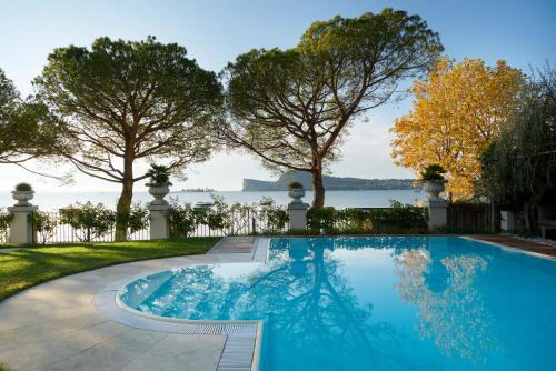 einen Pool mit Blick auf das Wasser und die Bäume in der Unterkunft Hotel Ristorante Sogno in San Felice del Benaco