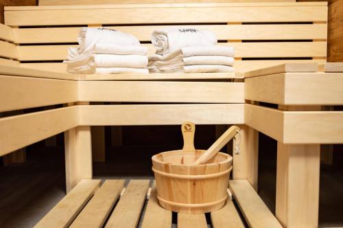 a wooden sauna with a bucket and towels at StrandBerg's Ursprung: Spa & Kitchen in Braunlage