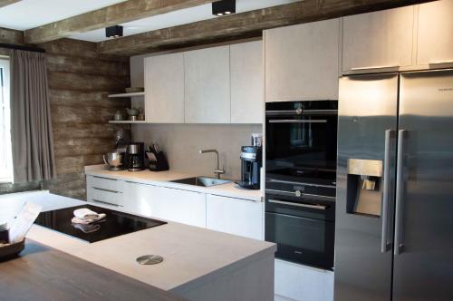 a kitchen with a stainless steel refrigerator and a sink at StrandBerg's Ursprung: Spa & Kitchen in Braunlage