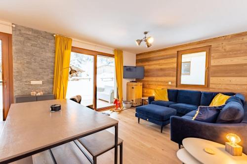 un salon avec un canapé bleu et une table dans l'établissement Morzine - Stylish 2 bed apartment near Les Prodains Gondola, à Morzine