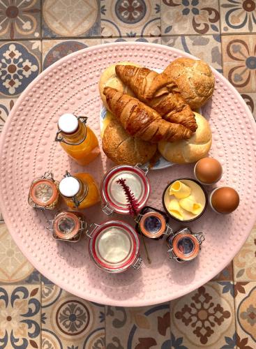 Ein rosa Teller mit Gebäck und Eiern auf einem Tisch in der Unterkunft B&B Berglust Rotterdam met serre en gratis parkeren in Rotterdam