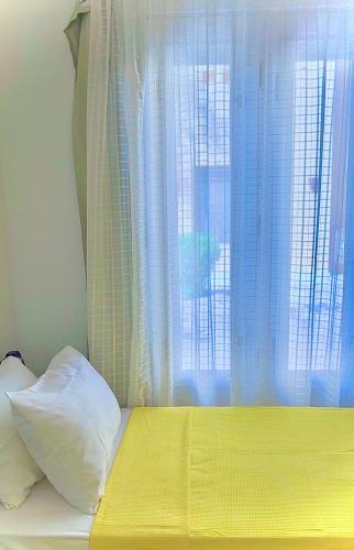 a bed with a yellow blanket and a window at South marina apartment MS10 Wi-Fi available in Hurghada