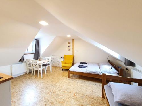 a attic bedroom with a bed and a desk at Apartmány U Muzea in Horní Blatná