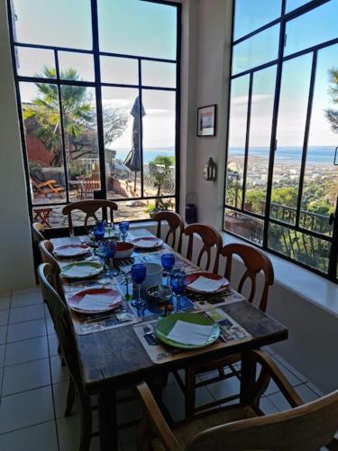 a dining room table with chairs and a view of the ocean at Villa Clarté Sète in Sète