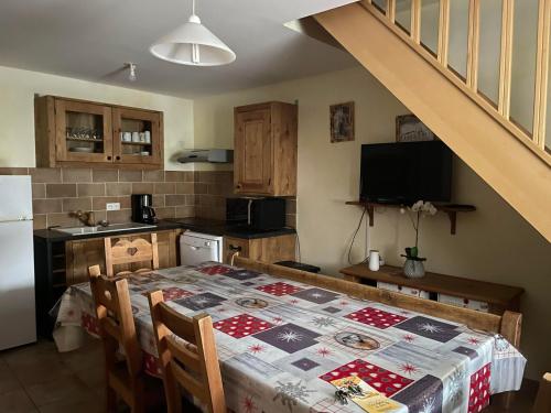 une cuisine avec une table recouverte d'une nappe dans l'établissement Deux appartements individuels de 8 personne à 200 mètres des remontées mécaniques au centre du village, à Saint-Sorlin-dʼArves