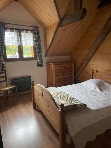 a bedroom with a bed in a wooden attic at Deux appartements individuels de 8 personne à 200 mètres des remontées mécaniques au centre du village in Saint-Sorlin-dʼArves