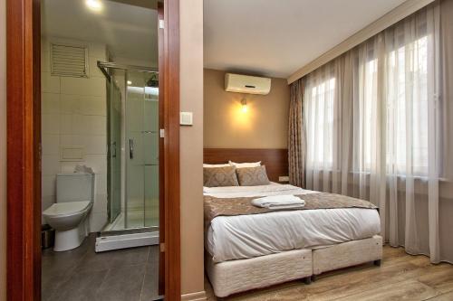 a bedroom with a bed and a shower and a toilet at Wide Suites Taksim in Istanbul