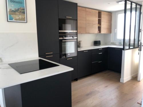 a kitchen with black cabinets and a white counter top at Vue mer exceptionnelle in Dinard