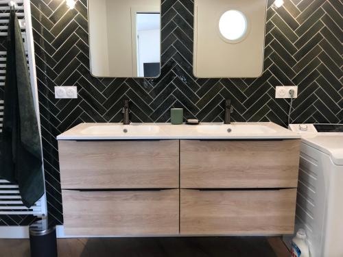 a bathroom with a sink and a mirror at Vue mer exceptionnelle in Dinard